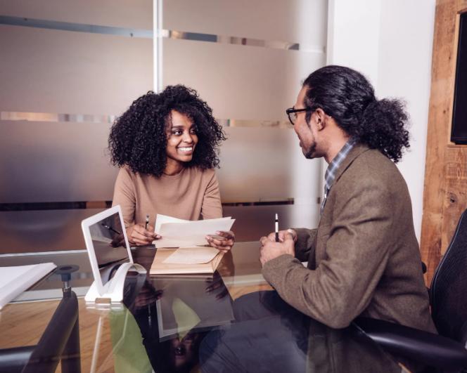 Two professionals having a life insurance career discussion at a desk