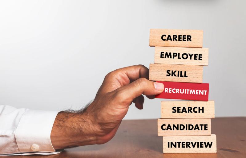 Hand pulling recruitment block from stack of career terms
