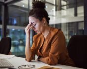 Tired insurance agent suffering from stress and fatigue while working late on a digital marketing project