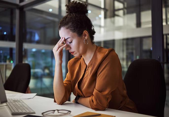 Tired insurance agent suffering from stress and fatigue while working late on a digital marketing project