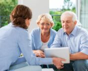 Life insurance agent showing policy options to smiling senior couple