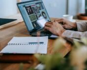 Person working from home on laptop reviewing insurance agent materials