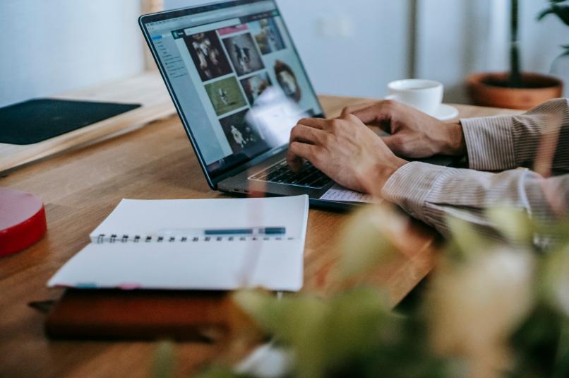Person working from home on laptop reviewing insurance agent materials