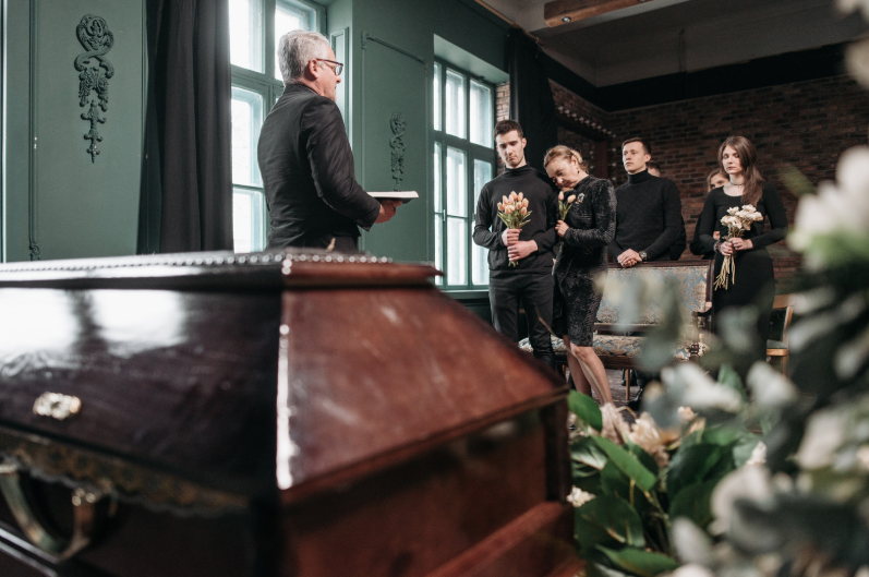 Family at funeral service with casket in foreground
