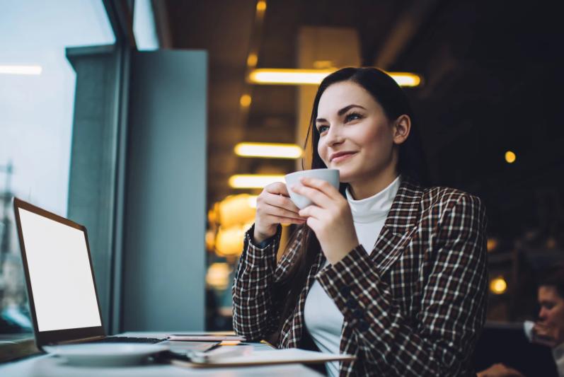 Remote life insurance agent working in a café with a laptop and coffee