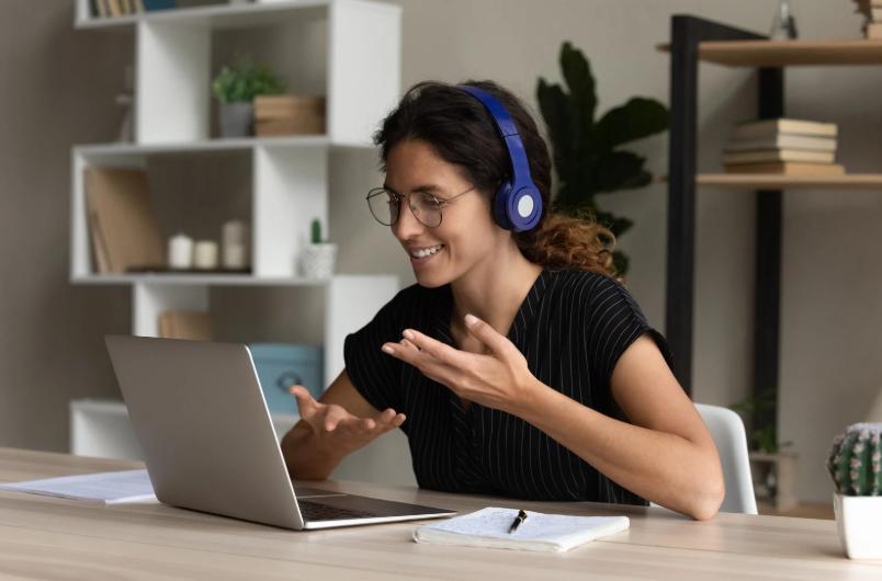 Woman wearing headset smiling during remote life insurance sales call