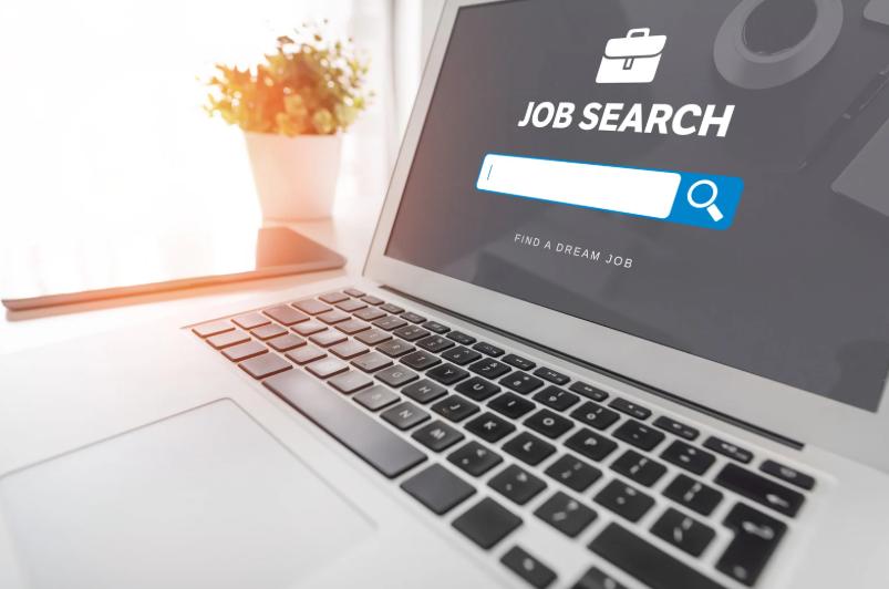Laptop screen with job search bar displaying text "Find a Dream Job"