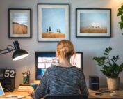 Woman working remotely on a dual-screen home office setup with modern decor