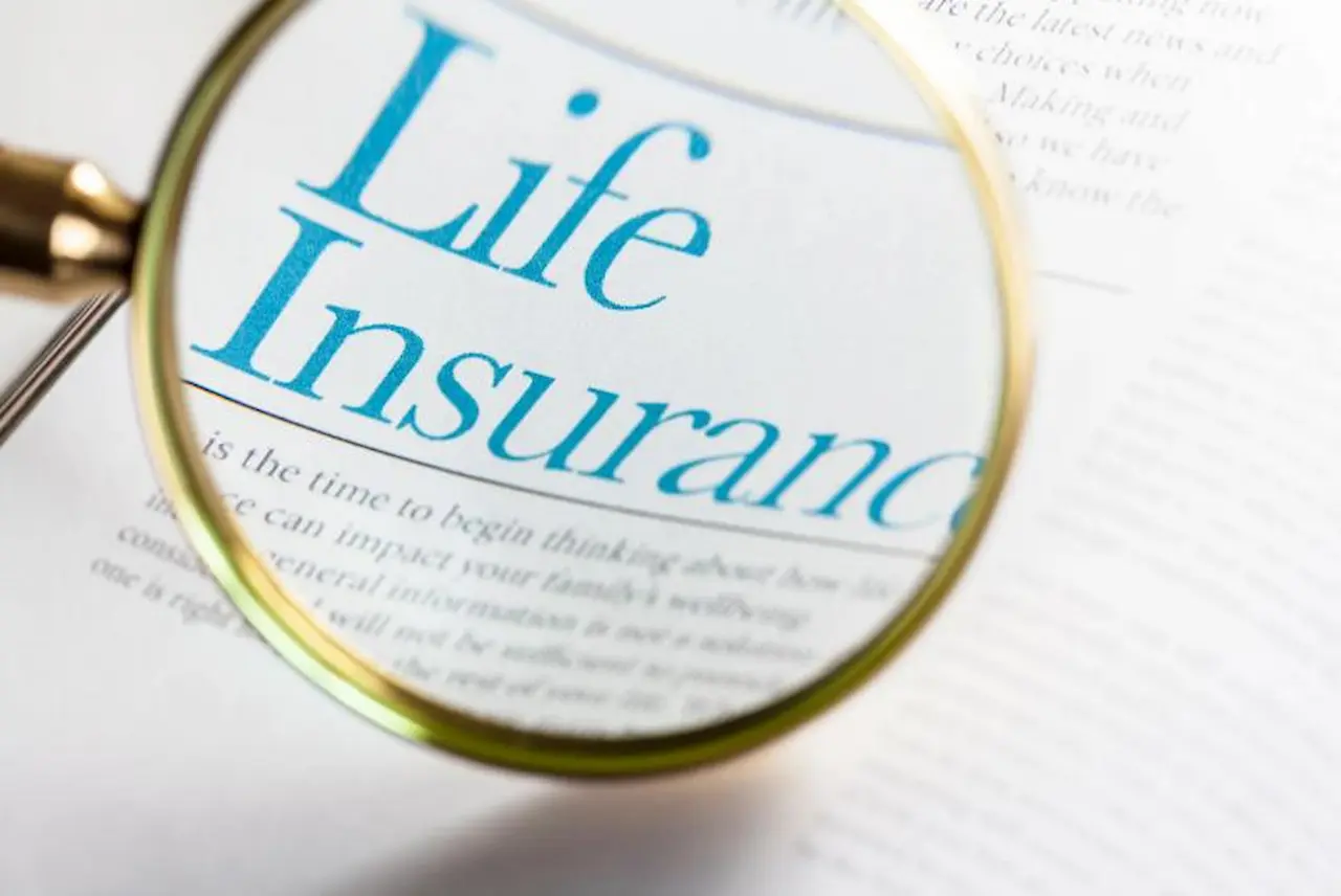 Magnifying glass highlighting the words life insurance on a white page