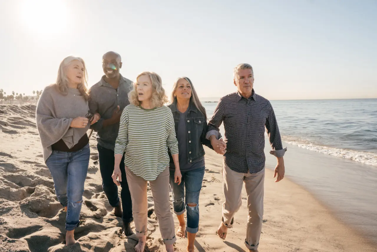 Group of older adults walking together on the beach