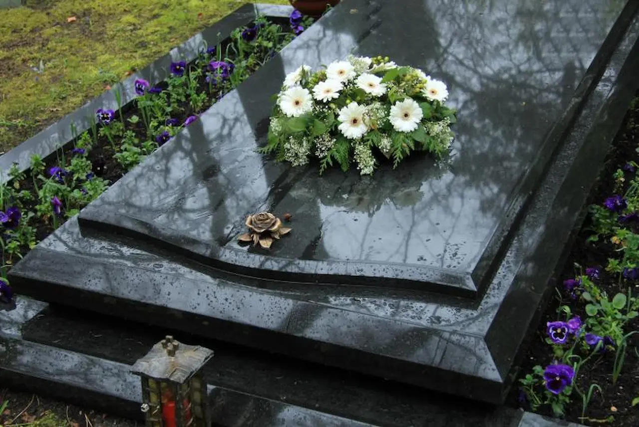 Funeral casket with Fresh Flowers Wet casket with white funeral flowers and a bronze rose